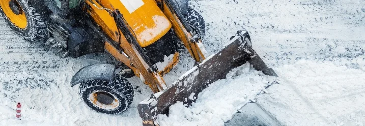 Traktor räumt Schnee mit Schaufel